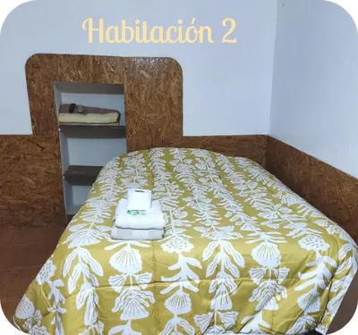a bed with a yellow and white blanket on it at Munay San Blas Wasi in Cusco