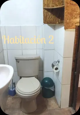 a bathroom with a white toilet and a sink at Munay San Blas Wasi in Cusco
