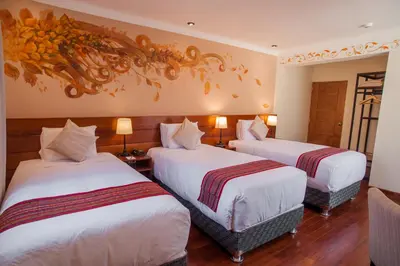 a hotel room with two beds and a painting on the wall at Casa Biru Hotel Boutique in Cusco