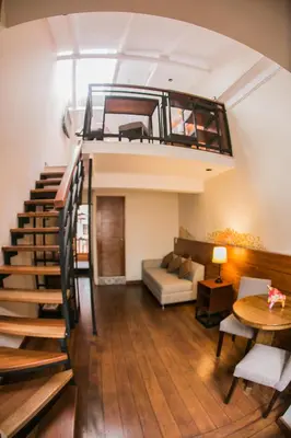 a living room with a staircase leading up to a loft at Casa Biru Hotel Boutique in Cusco