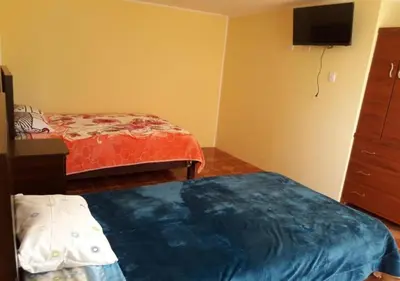 a bedroom with two beds and a tv on the wall at La Azotea in Huancayo