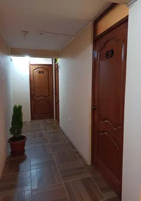 an empty hallway with two doors and a potted plant at La Azotea in Huancayo