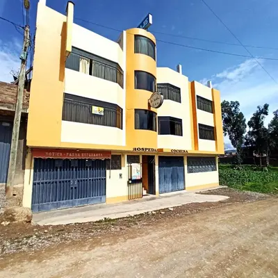 a yellow and white building with two garage doors at La Azotea in Huancayo