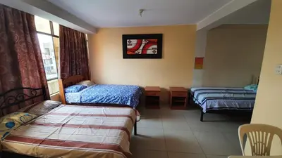 a hotel room with two beds and a window at Hostal refugio's in Ica