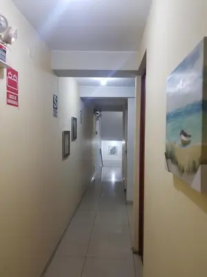 a hallway in a building with paintings on the walls at Hostal refugio's in Ica