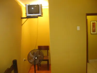 a room with a fan and a tv on a wall at Posada Gino in Pisco
