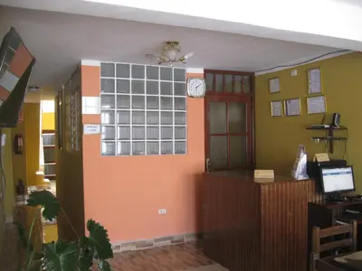 a room with a wall with a clock on it at Posada Gino in Pisco