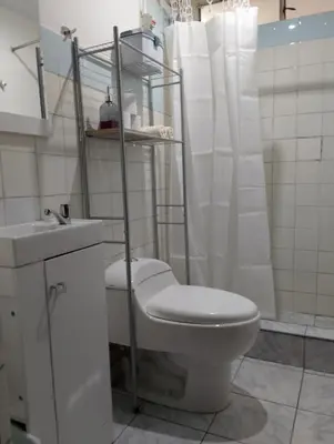 a white bathroom with a toilet and a sink at MUNAYCHA`S WASI in Cusco