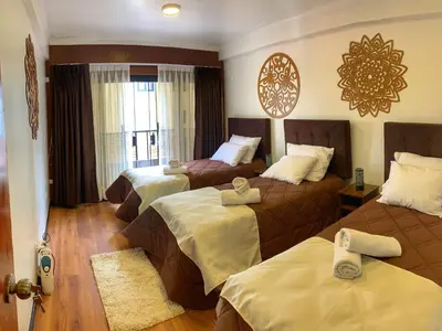 a hotel room with two beds and a window at Apartamento a pasos de la Plaza Cusco Inlove in Cusco