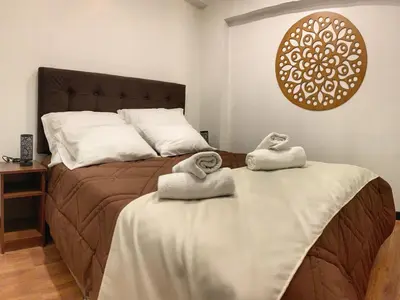 a bedroom with a bed with two towels on it at Apartamento a pasos de la Plaza Cusco Inlove in Cusco