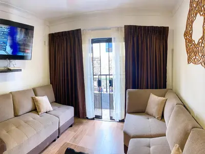 a living room with a couch and a tv at Apartamento a pasos de la Plaza Cusco Inlove in Cusco