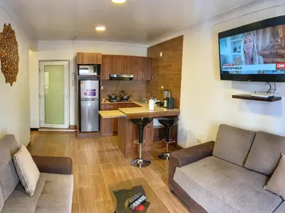 a living room with a couch and a tv on the wall at Apartamento a pasos de la Plaza Cusco Inlove in Cusco