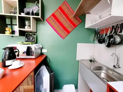 a kitchen with a counter with a microwave and a sink at wayra house san blas in Cusco
