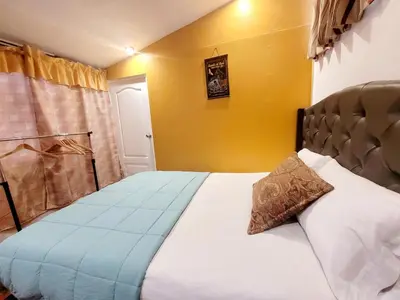a bedroom with a large bed with a yellow wall at wayra house san blas in Cusco