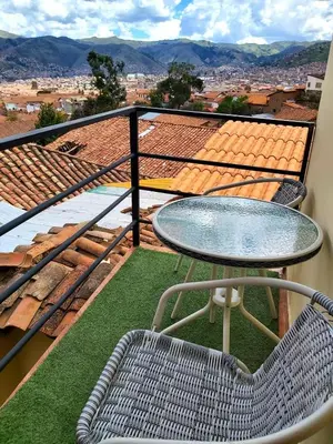 a table and chair on a balcony with a view at wayra house san blas in Cusco