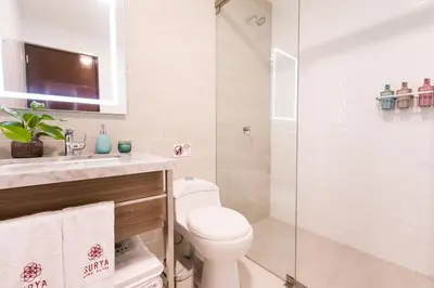 a bathroom with a toilet and a glass shower at Surya Lima in Lima