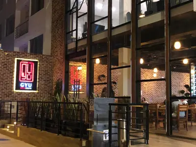 a restaurant with a brick wall and a neon sign at Surya Lima in Lima