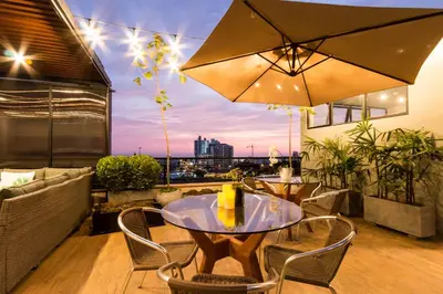 a patio with a table and chairs and an umbrella at Surya Lima in Lima