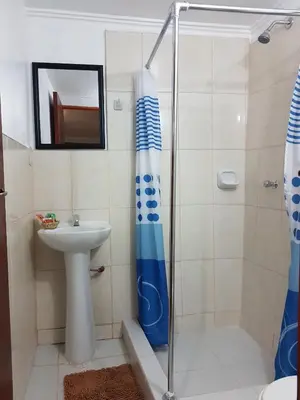 a bathroom with a shower and a sink at Kurumi Hostel in Cusco