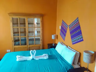 a bedroom with a bed with a blue comforter at Kurumi Hostel in Cusco