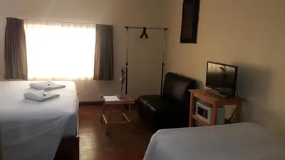 a hotel room with a bed and a chair and a television at Kurumi Hostel in Cusco