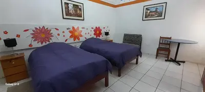 a room with two beds and a table in it at Kurumi Hostel in Cusco