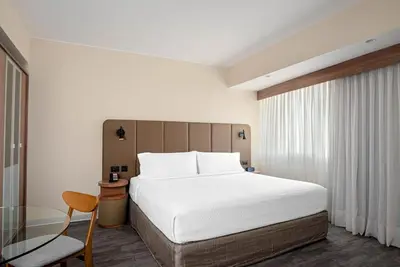 a bedroom with a large bed and a glass table at Crowne Plaza Lima by IHG in Lima