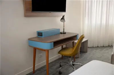 a desk with a blue drawer and a yellow chair at Crowne Plaza Lima by IHG in Lima
