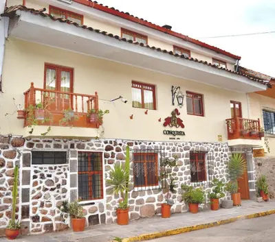 a building with potted plants in front of it at Conquista Cusco in Cusco