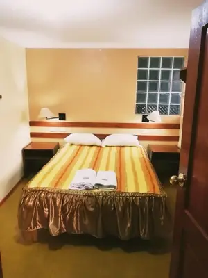 a bedroom with a bed with two towels on it at Conquista Cusco in Cusco