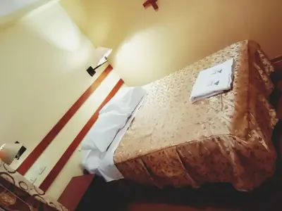 a hotel room with a bed with a lamp at Conquista Cusco in Cusco