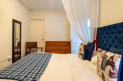 a bedroom with a bed with a blue headboard and a window at Británico en Miraflores & primer piso, 3 dormitorios in Lima