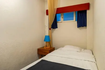 a small bedroom with a bed and a blue lamp at Británico en Miraflores & primer piso, 3 dormitorios in Lima