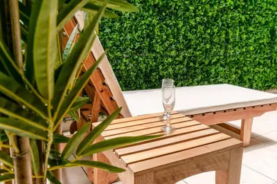 a wine glass sitting on a wooden bench next to a plant at Británico en Miraflores & primer piso, 3 dormitorios in Lima