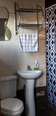 a bathroom with a white sink and a toilet at Nice studio in historic center with private bathroom and kitchen! in Cusco