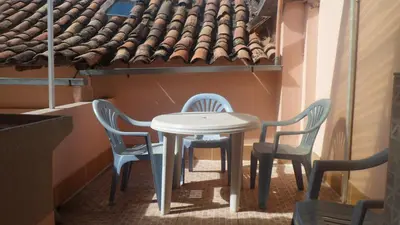 a table and chairs in a room with a roof at Nice studio in historic center with private bathroom and kitchen! in Cusco