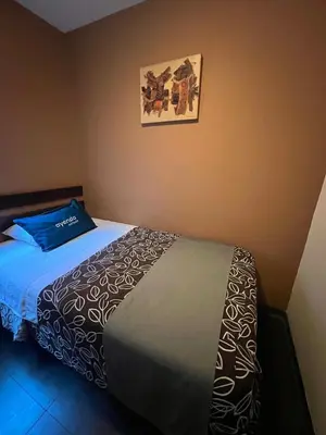 a bedroom with a bed and a picture on the wall at B&B Wasi Airport Lima in Lima