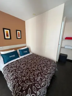 a bedroom with a large bed with blue pillows at B&B Wasi Airport Lima in Lima