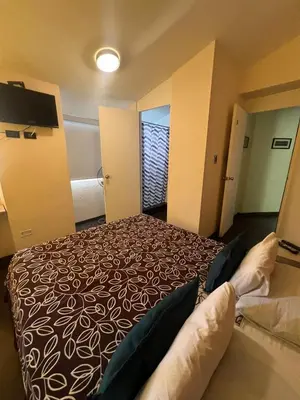 a hotel room with a bed and a window at B&B Wasi Airport Lima in Lima
