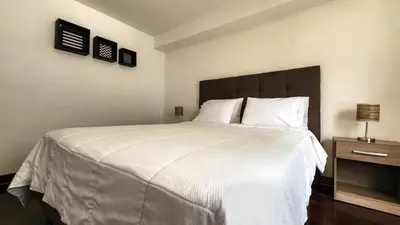 a bedroom with a large bed with white sheets and pillows at Hermoso departamento en el Corazón de Miraflores in Lima