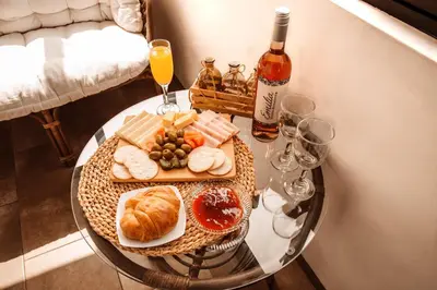 a glass table with a tray of food and a bottle of wine at Hermoso departamento en el Corazón de Miraflores in Lima