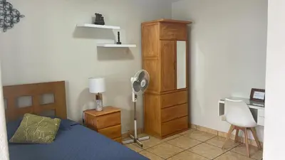 a bedroom with a bed and a desk and a fan at Habitación Alborada 2 con baño privado in Lima