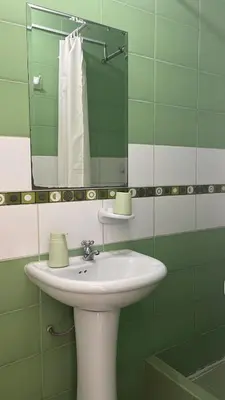 a bathroom with a white sink and a mirror at Habitación Alborada 2 con baño privado in Lima