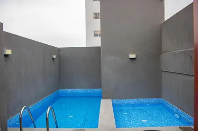 a swimming pool with blue water in a building at Departamento 100 m2 con luz natural y Seguridad 24h in Lima