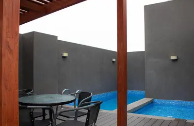 a patio with a table and chairs and a pool at Departamento 100 m2 con luz natural y Seguridad 24h in Lima