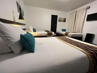 a hotel room with two beds with blue pillows at SACHA Centric in Cusco
