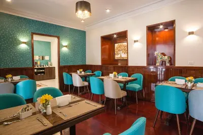 a restaurant with wooden tables and blue chairs at SACHA Centric in Cusco