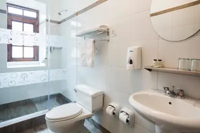 a white bathroom with a toilet and a sink at SACHA Centric in Cusco