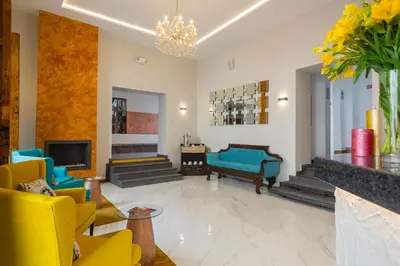 a living room with yellow and blue furniture and a chandelier at SACHA Centric in Cusco