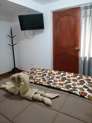 a stuffed animal laying on the floor next to a bed at Casa ValPer in Cusco